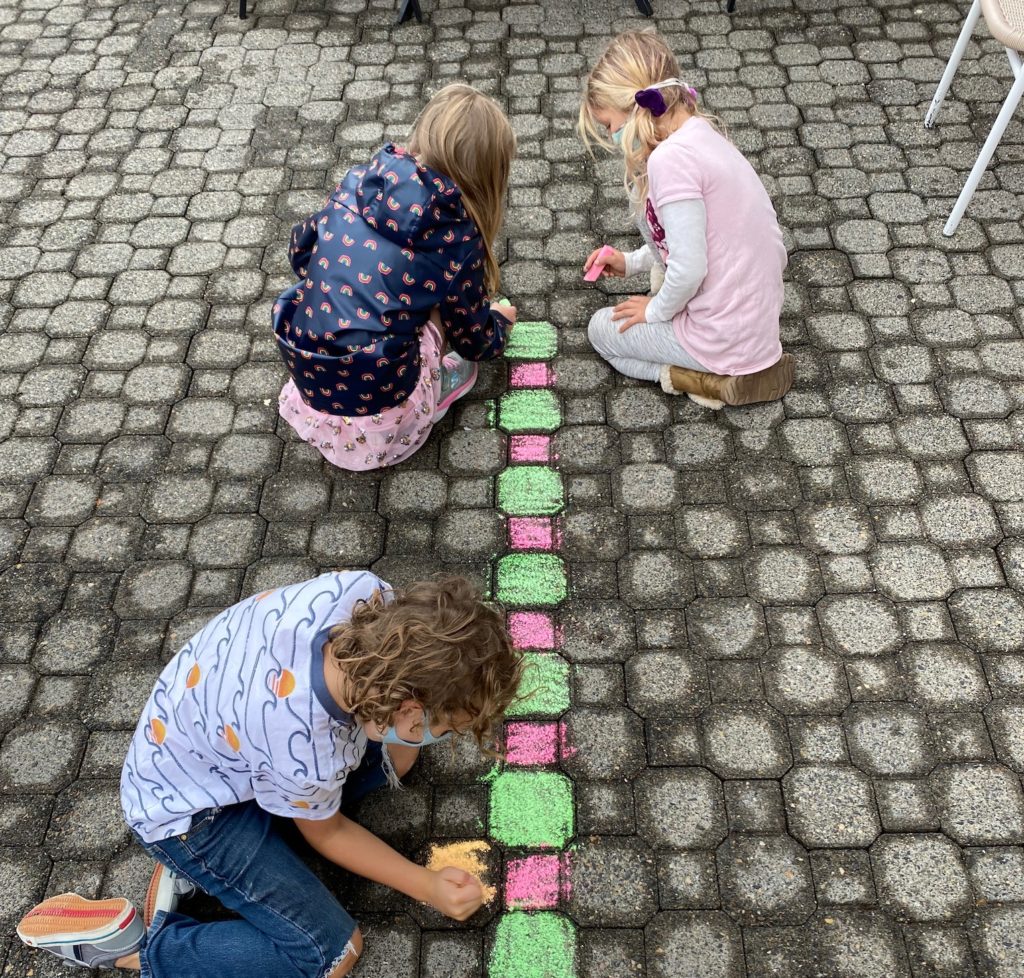 Kids planning outside with chalk at VIDA coworking childcare