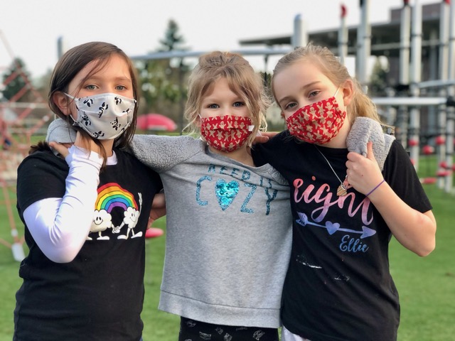 three young girls at a park while wearing marks