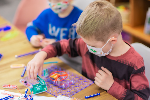 a young boy playing a learning game at summer day camp