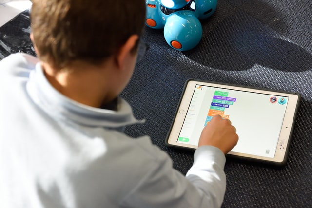 a young boy playing with a tablet