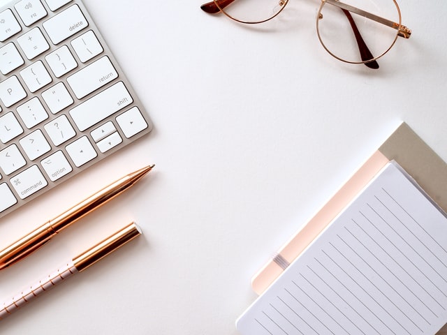 a desktop with a keyword, pens and notepad