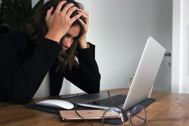 an unhappy woman working at a computer