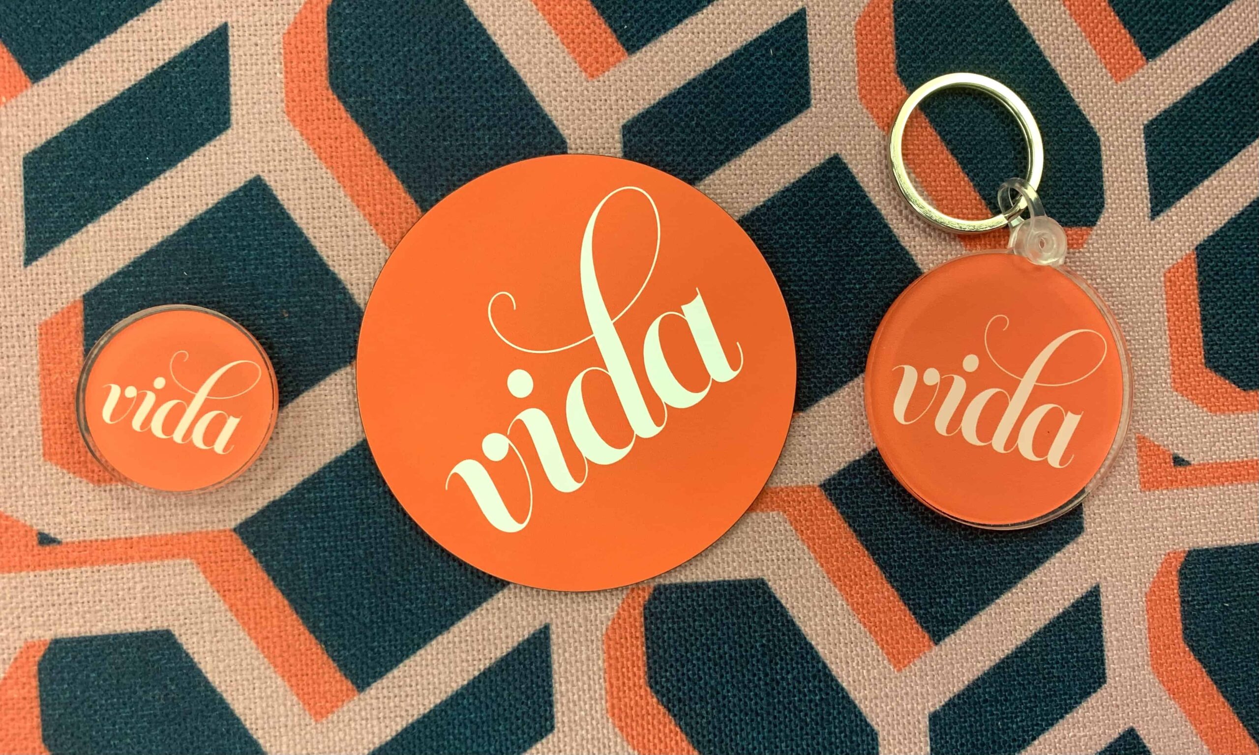 The VIDA logo over a green, orange, and beige background