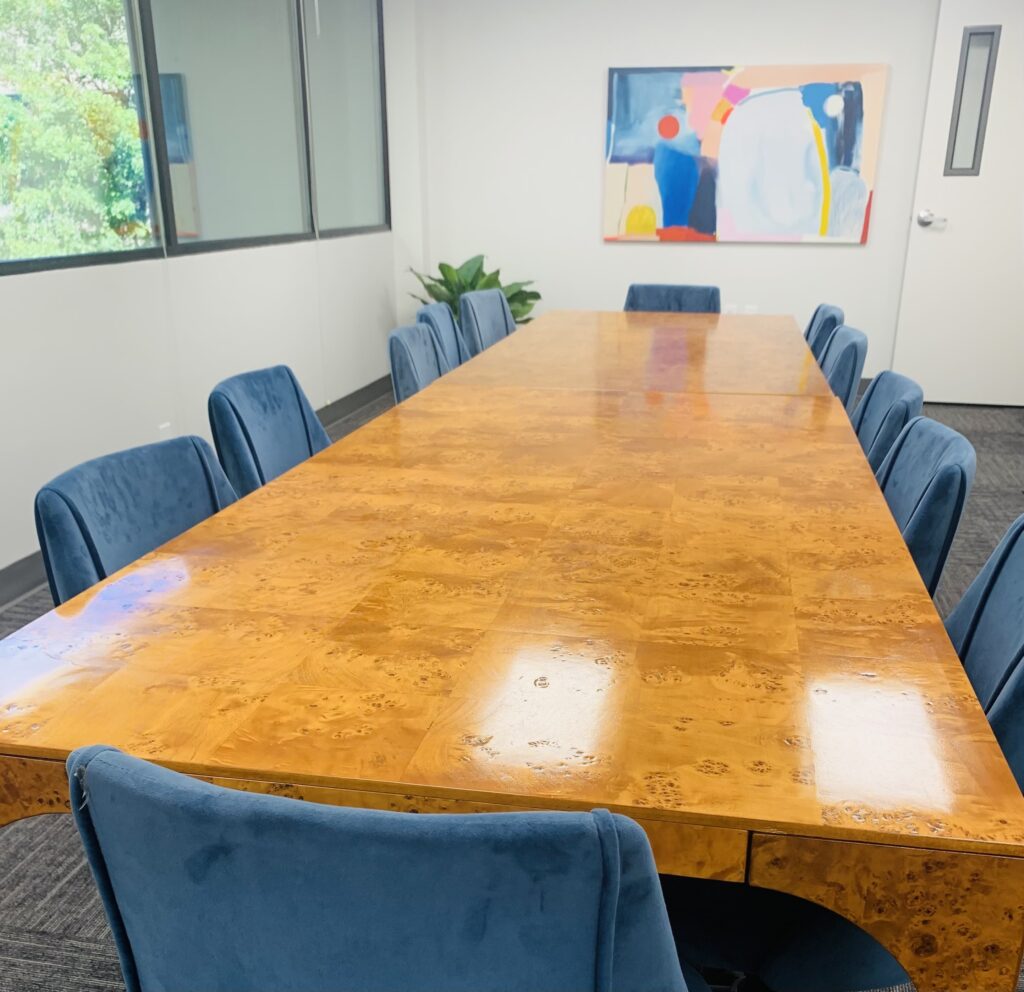 A large pright conference room that can seat at least 12 people at a long wooden table