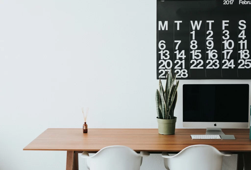 A Bright white wall with a wooden table in front of it