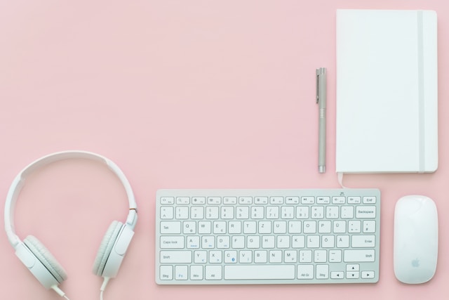 a pink desktop with a keyboard and headphones
