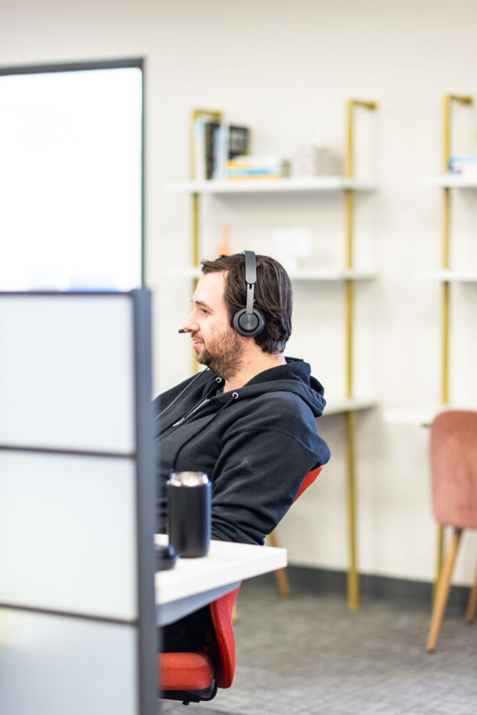 A man wearing headphones working on his laptop