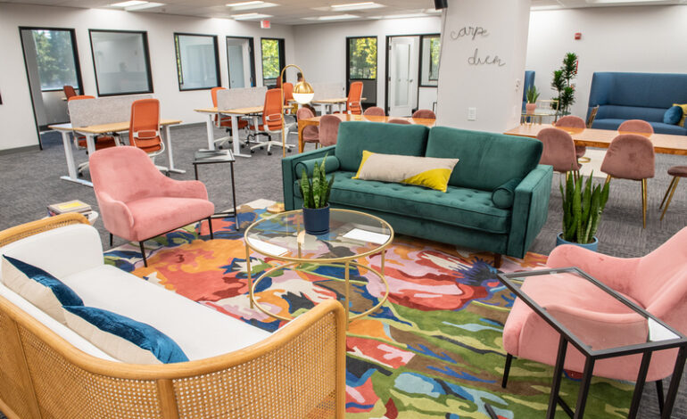 The bright and colorful interior of VIDA coworking with copious workspaces for both solo and group work. There are tables and chairs, as well as couches with coffee tables