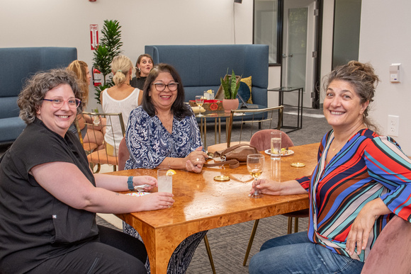Three women sitting at a coffee table smiling