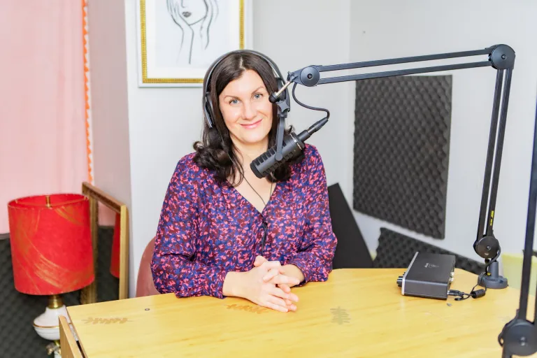 Melanie Marconi sitting behind a podcast microphone