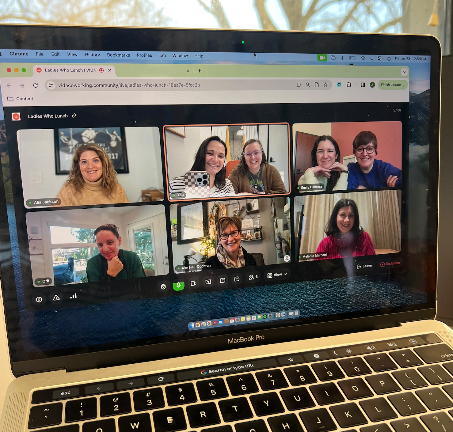 A laptop screen with a video call on it featuring 6 different participants