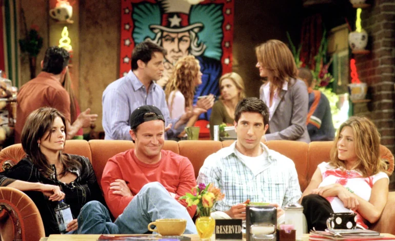 The cast of Friends sitting together at the fictional coffee shop, Central Perk.